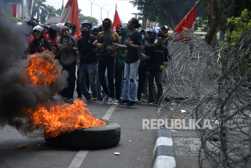 Sejumlah buruh dan mahasiswa membakar ban bekas saat berunjuk rasa di depan kantor DPRD Sulsel, Makassar, Sulawesi Selatan, Kamis (8/10/2020). Mereka menolak Undang-undang (UU) Omnibus Law Cipta Kerja yang telah disahkan oleh DPR karena dinilai merugikan para pekerja. 