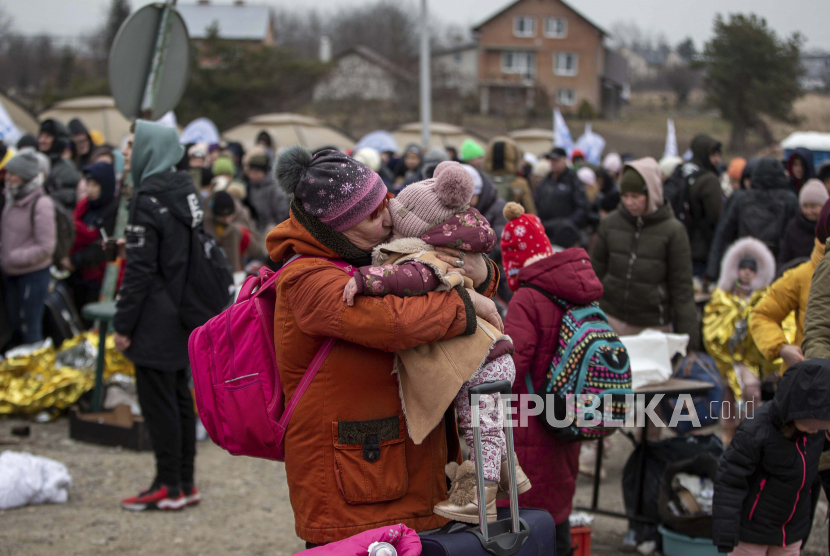Seorang wanita mencium seorang anak setelah melarikan diri dari Ukraina dan tiba di perbatasan di Medyka, Polandia, Senin, 7 Maret 2022. 