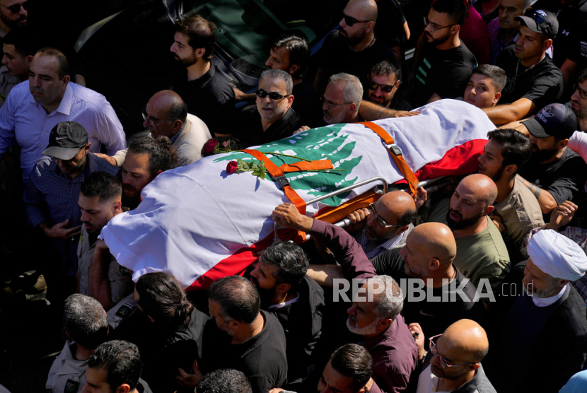 Para pelayat membawa jenazah videografer Reuters Issam Abdallah yang tewas akibat tembakan Israel saat prosesi pemakamannya di kampung halamannya di Khiam, Lebanon selatan, Sabtu, 14 Oktober 2023.