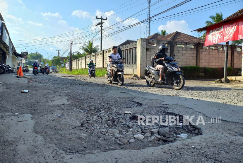 Sejumlah pengguna kendaraan melintas di ruas Jalan Leuwisari, Desa Arjasari, Kecamatan Leuwisari, Kabupaten Tasikmalaya, Jawa Barat, yang kondisinya rusak, Rabu (10/5/2023). 