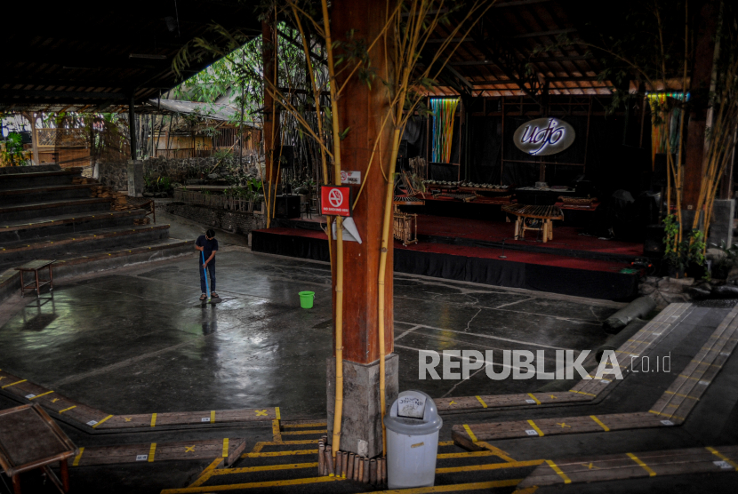 Pekerja membersihkan lantai aula pertunjukan di Saung Angklung Udjo, Bandung, Jawa Barat, Ahad (24/1/2021). Direktur Utama Saung Angklung Udjo Taufik Hidayat Udjo menyatakan, Saung Angklung Udjo tercancam akan ditutup akibat pandemi COVID-19 yang membuat penurunan pengunjung secara signifikan ke pusat kebudayaan musik sunda yang telah didirikan sejak 1966 tersebut. 