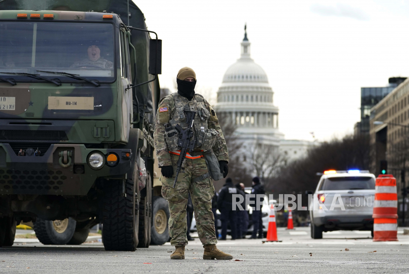  Seorang Pengawal Nasional berdiri di blok jalan di luar Capitol saat keamanan ditingkatkan menjelang upacara pelantikan Presiden terpilih Joe Biden Senin, 18 Januari 2021, di Washington.
