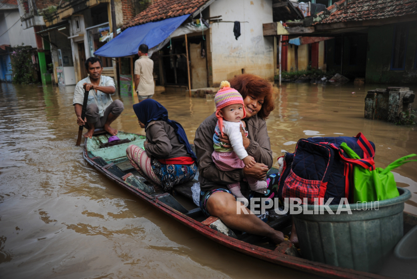 Warga menggunakan perahu melintasi banjir yang melanda Bojongasih, Dayeuhkolot, Kabupaten Bandung, Jawa Barat, Jumat (25/12/2020). Hujan lebat yang melanda Bandung Raya sejak Kamis (24/12) sore hingga malam hari menyebabkan 7.364 rumah di Dayeuhkolot dan Baleendah terendam banjir akibat luapan Sungai Citarum dengan ketinggan 30 hingga 150 sentimeter