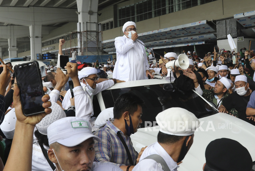  Ulama Indonesia dan pemimpin Front Pembela Islam (FPI) Rizieq Shihab (tengah) menyapa para pendukungnya saat kedatangannya dari Arab Saudi di Bandara Internasional Soekarno-Hatta di Tangerang, Indonesia, 10 November 2020 (diterbitkan kembali pada 07 Desember 2020). 