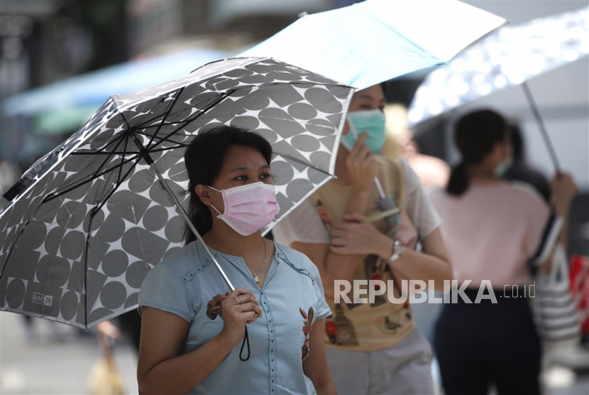  Pejalan kaki menggunakan payung untuk melindungi sinar matahari saat cuaca panas di Bangkok, Thailand, Jumat (28/4/2023). 