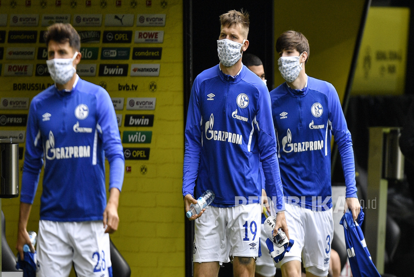 epa08426519 Schalkes Guido Burgstaller (C) arrives with a protective face mask prior to the German Bundesliga soccer match between Borussia Dortmund and Schalke 04 in Dortmund, Germany, 16 May 2020. The German Bundesliga and Second Bundesliga are the first professional leagues to resume the season after the nationwide lockdown due to the ongoing Coronavirus (COVID-19) pandemic