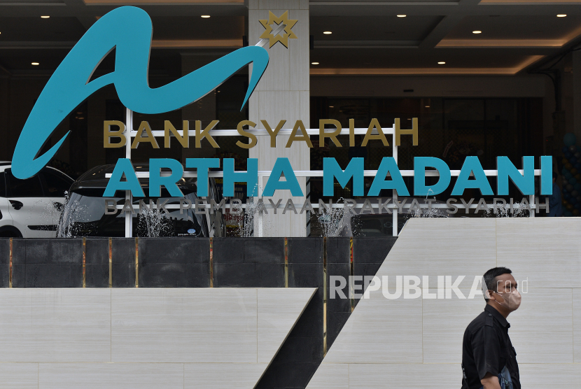 Warga berjalan di depan gedung baru BPRS Bank Syariah Artha Madani yang baru diresmikan di Bekasi, Jawa Barat, Rabu (7/9/2022). Otoritas Jasa Keuangan (OJK) memproyeksikan jumlah bank perkreditan rakyat (BPR) akan berkurang signifikan.