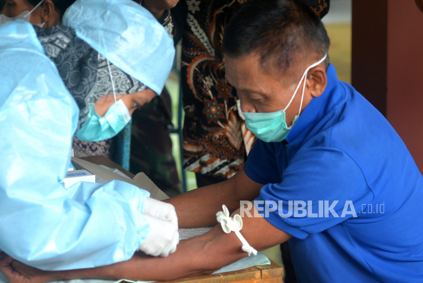 Petugas kesehatan mengambil sampel darah warga di Balai Dusun Jati, Semanu, Gunungkidul, Yogyakarta, Jumat (7/7/2023). Pengambilan sampel kedua imbas kasus satu kematian dan 87 terpapar antraks imbas mengonsumsi daging sapi yang terjangkit antraks. Hal ini dilakukan untuk memastikan apakah warga positif antraks atau tidak. Pengambilan sampel ini dilakukan ke seluruh warga Dusun Jati.
