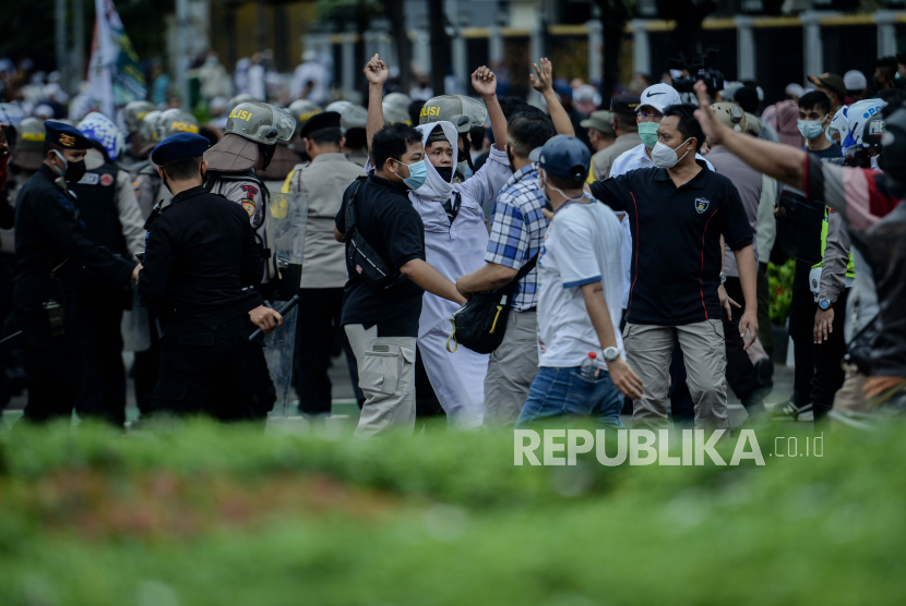 Aparat kepolisian mengamankan sejumlah massa aksi  unjuk rasa 1812 Front Pembela Islam (FPI) yang hendak menggelar aksi di sekitar Patung Kuda Arjuna Wiwaha, Jakarta Pusat, Jumat (18/12). Polisi memukul mundur massa yang menolak dibubarkan guna menghindari kerumunan. Sebanyak 5.000 personel gabungan dari unsur TNI-Polri dan Pemprov DKI Jakarta disiapkan untuk mengawal dan mengamankan unjuk rasa 1812 di kawasan Istana Negara. Republika/Thoudy Badai