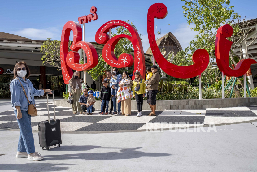  Wisatawan yang tiba di Bandara Internasional Ngurah Rai berpose untuk foto kenang-kenangan di depan logo Bali, di Kuta, pulau Bali, Kamis (5/1/2023). Kementerian Pariwisata mengatakan negara akan siap menyambut wisatawan dari China mengikuti rencananya untuk membuka kembali perbatasan pada 08 Januari 2023.