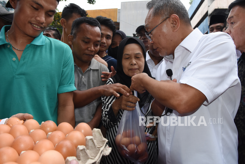 Menteri Perdagangan Zulkifli Hasan (kanan) membelikan telur kepada sejumlah warga saat digelar Operasi Pasar Telur Ayam Ras di Pasar Minggu, Jakarta, Jumat (2/9/2022). Pasar murah yang diselenggarakan Badan Pangan Nasional itu dalam upaya stabilisasi pasokan dan harga telur ayam ras yang belakangan ini meningkat di atas Rp30ribu per kg, sementara di pasar murah tersebut dijual seharga Rp27ribu per kg. 