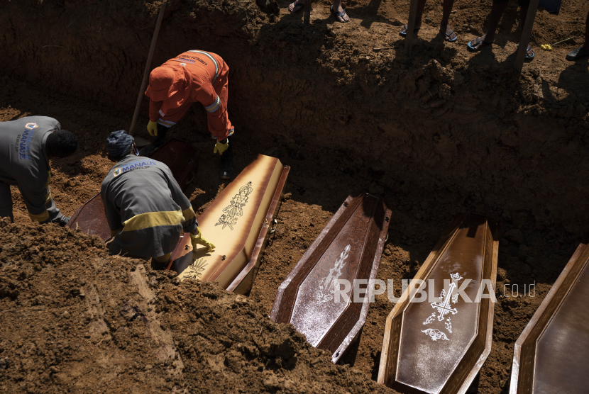 Pekerja makam menempatkan peti mati di kuburan umum selama pemakaman di pemakaman Nossa Senhora Aparecida, di tengah pandemi coronavirus baru di Manaus, Brasil, Senin, 11 Mei 2020. 