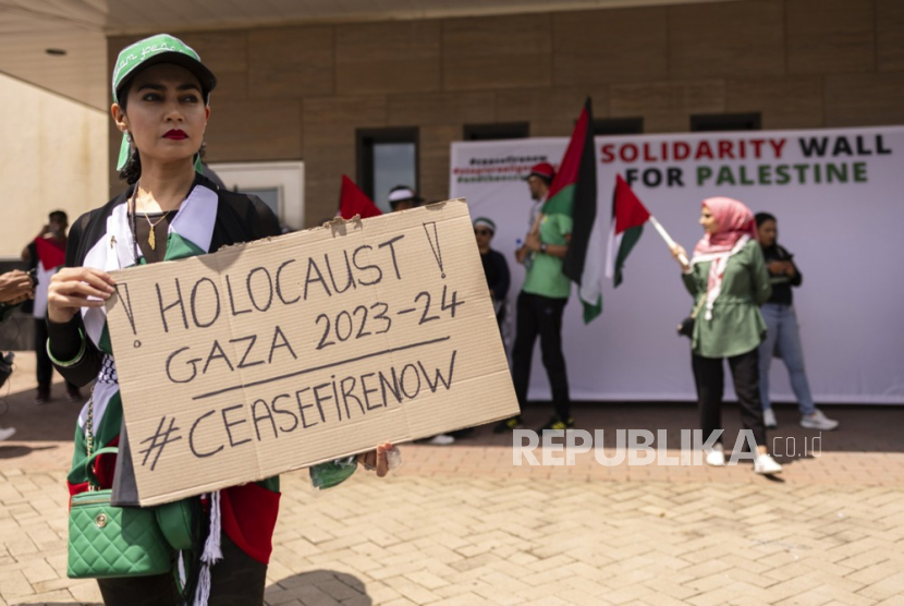 Seorang pengunjuk rasa membawa plakat saat protes kemerdekaan Palestina di Konsulat Amerika Serikat sebagai bagian dari hari aksi global untuk mendukung Palestina merdeka, di Johannesburg, Afsel. 