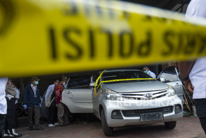 Sejumlah petugas Komnas HAM dan polisi memeriksa satu dari tiga mobil yang dikendarai polisi dan enam laskar FPI dalam kasus penembakan anggota FPI di Polda Metro Jaya, Jakarta, Senin (21/12/2020).  