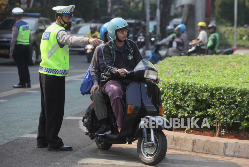 Polisi memberikan arahan kepada pengendara saat uji coba tilang uji emisi di Terminal Blok M, Jakarta Selatan, Jumat (25/8/2023). Pemerintah Provinsi DKI Jakarta bersama Polda Metro Jaya melakukan uji coba tilang uji emisi di lima wilayah DKI Jakarta sebelum diberlakukan sanksi tilang pada 1 September 2023. Denda sanksi tilang bagi kendaraan yang tidak lulus uji emisi sebesar Rp 250.000 bagi kendaraan motor dan Rp 500.000 bagi kendaraan mobil.