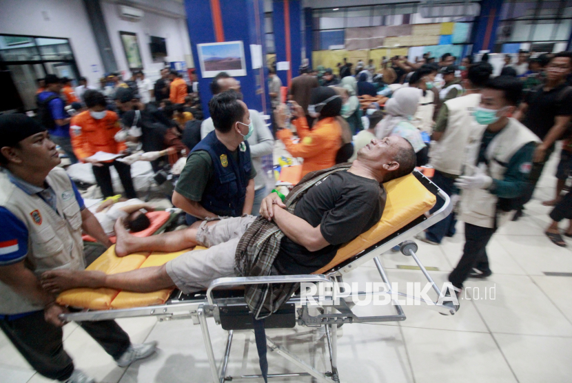 Petugas medis membawa seorang korban selamat yang terluka akibat kecelakaan kapal feri saat tiba di pelabuhan di Banjarmasin, Kalimantan Selatan, Ahad (13/9/2026). Setidaknya 100 orang dilaporkan hilang setelah kapal feri penumpang KM Virgo Transport 8—yang sedang dalam perjalanan dari Surabaya menuju Banjarmasin dengan membawa 243 penumpang—menghadapi cuaca buruk di Laut Jawa. Pihak berwenang berhasil menyelamatkan lebih dari 100 orang.