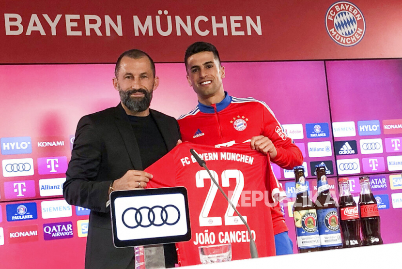 Direktur Olahraga FC Bayern Munchen Hasan Salihamidzic (kiri) menghadirkan rekrutan baru Joao Cancelo pada konferensi pers di Munich, Jerman, Selasa, Selasa (31/1/2023).