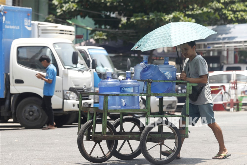 Seorang pria mendorong gerobak dengan botol air minum di jalan di Yangon, Myanmar, 25 April 2023. Junta militer secara resmi telah menunda pelaksanaan pemilu yang dijanjikan pada Agustus 2023.