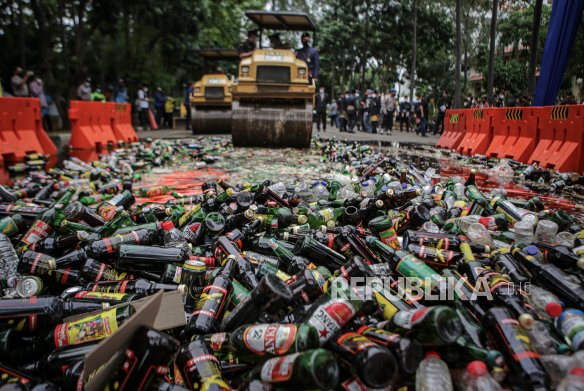 Petugas menggunakan alat berat menggilas botol-botol minuman keras saat pemusnahan di kawasan Puspem Kota Tangerang, Banten, Senin (28/2/2022). Sebanyak 4.837 minuman keras dalam berbagai kemasan hasil penertiban sejak satu tahun terakhir dimusnahkan pemerintah Kota Tangerang. 