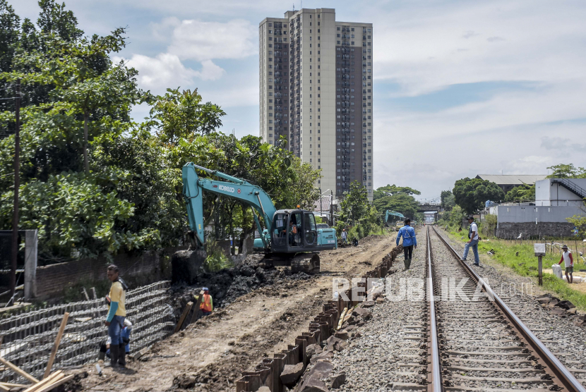 Pekerja beraktivitas di area proyek jalur ganda (double track) di Cisaranten Kulon, Arcamanik, Kota Bandung, Selasa (20/9/2022). Proyek jalur ganda kereta api Kiaracondong-Cicalengka sepanjang 23,5 kilometer tersebut ditargetkan rampung pada tahun 2023 mendatang. Proyek tersebut diharapkan mampu memangkas waktu tempuh dari Bandung-Cicalengka menjadi 23 menit serta meningkatkan pelayanan kereta api. Republika/Abdan Syakura