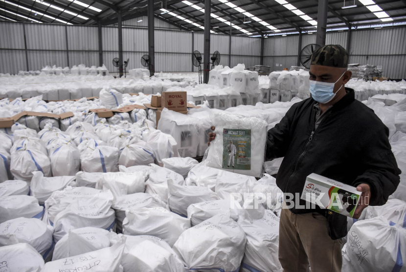 Petugas menyiapkan logistik protokol kesehatan di Gudang KPU Kabupaten Bandung, Kampung Sawah, Soreang, Kabupaten Bandung, Kamis (3/12). Komisi Pemilihan Umum (KPU) Kabupaten Bandung menyiapkan logistik protokol kesehatan seperti pakaian hazmat, masker, sarung tangan, sabun, tempat cuci tangan dan pelindung wajah yang kemudian akan di distribusikan ke 6.874 TPS guna meminimalisir penyebaran Covid-19 saat pelaksanaan Pilkada Kabupaten Bandung 2020 pada Desember mendatang. Foto: Abdan Syakura/Republika