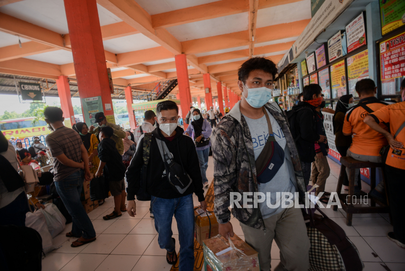 Penumpang berjalan untuk menaiki bus di Terminal Kampung Rambutan, Jakarta, Senin (26/4).