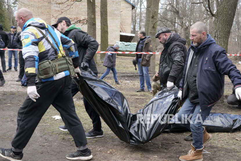 Relawan mengumpulkan mayat warga sipil yang terbunuh, di Bucha, dekat Kyiv, Ukraina, Senin, 4 April 2022. Ketua majelis rendah parlemen Rusia tuding kasus Bucha adalah tindakan curang Barat.