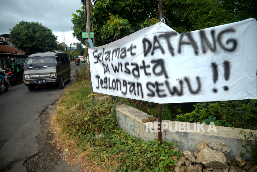 Spanduk protes terpasang sebagai bentuk protes jalan berlubang di Kelurahan Wirokerten, Bantul, Yogyakarta, Rabu (5/7/2023). Warga menanam pohon pisang di jalan berlubang serta memasang spanduk protes imbas kerusakan di Jalan Monumen Perjuangan. Selain itu, warga juga menandai lubang di jalan menggunakan cat putih. Panjang jalan yang rusak sekitar 300 meter. Warga berharap kerusakan jalan segera diperbaiki karena bisa membahayakan pengguna jalan.