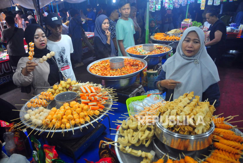 Warga memilih makanan saat mengunjungi pasar malam dalam Tradisi Dandangan di Kudus, Jawa Tengah, Selasa (5/3/2024). Tradisi setahun sekali yang berlangsung hingga Ahad (10/3) tersebut diikuti 680 pedagang dengan menjual berbagai produk Usaha Mikro Kecil dan Menengah (UMKM) dari berbagai daerah untuk menyambut datangnya bulan Ramadhan 1445 Hijriah sekaligus upaya mendukung UMKM naik kelas.  