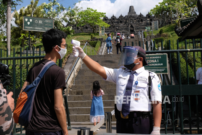 Petugas memeriksa suhu tubuh wisatawan yang akan masuk ke zona 1 kawasan Taman Wisata Candi (TWC) Borobudur, Magelang, Jawa Tengah, Rabu (8/7/2020). Pihak Balai Konservasi Borobudur (BKB) membuka kembali zona 1 candi Borobudur untuk umum yang ditutup akibat pandemi COVID-19 sejak (15/7/2020), tapi pengunjung belum diperbolehkan menaiki struktur candi Borobudur. 