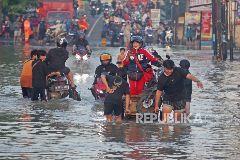 Pengendara motor menggunakan jasa ojek gerbok untuk melintasi banjir yang merendam Jalan KH Hasyim Ashari dan Perumahan Ciledug Indah, Ciledug, Tangerang, Banten. Pemkot Tangerang menyiapkan danau buatan untuk mengatasi banjir di Kunciran.