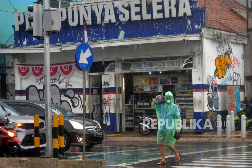 Warga menggunakan jas hujan menembus hujan di kawasan Tugu Pal Putih, Yogyakarta. Cuaca Hari Ini: Hujan Ringan Hingga Lebat Diprakirakan Turun di Sejumlah Kota Besar