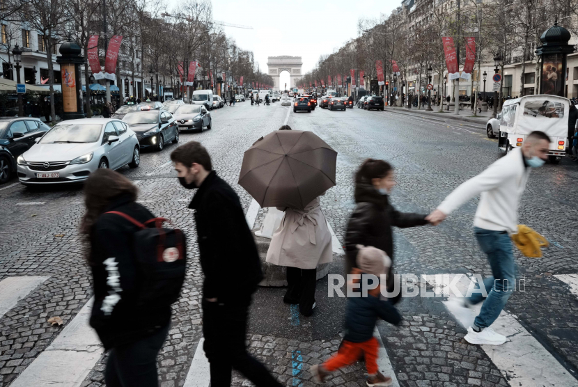 Orang-orang melintasi jalan Champs Elysees, di Paris, Selasa, 28 Desember 2021. Parlemen Prancis menyetujui rencana Presiden Macron menerapkan kartu vaksin. Ilustrasi.