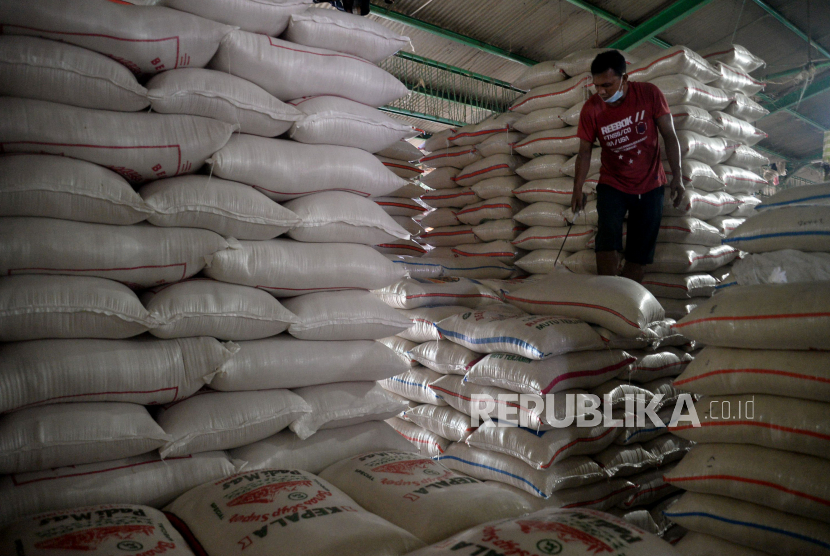 Pekerja menata tumpukan karung beras di Pasar Induk Cipinang , Jakarta Timur, Selasa (27/10).