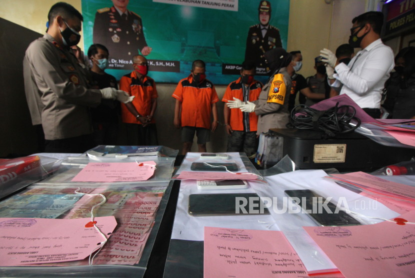 Polisi menunjukkan barang bukti dan tersangka saat ungkap kasus pemalsuan dokumen hasil tes cepat (rapid test) di Polres Pelabuhan Tanjung Perak Surabaya, Jawa Timur, Senin (21/12/2020). Polres Pelabuhan Tanjung Perak Surabaya menangkap tiga tersangka atas kasus dugaan membuat dokumen palsu hasil tes cepat (rapid test) dan mengamankan barang  bukti beberapa diantaranya satu laptop, stempel, alat cetak, sepuluh lembar hasil rapid test palsu. 