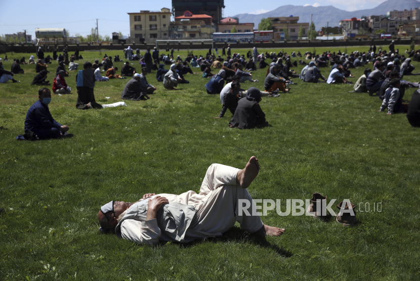  Warga Afghanistan menunggu untuk menerima gandum gratis yang disumbangkan oleh pemerintah Afghanistan menjelang bulan puasa Ramadhan mendatang, selama karantina untuk coronavirus, di Kabul, Afghanistan, Selasa (21/4/2020). 