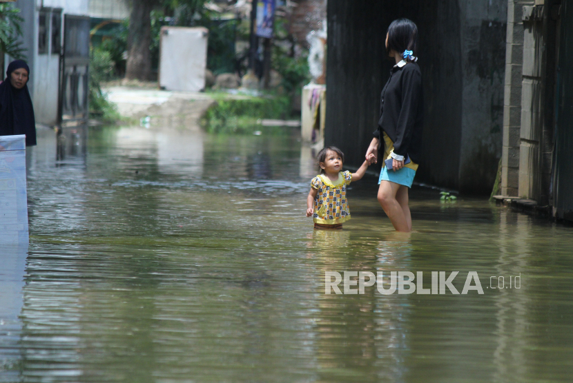 Warga melintasi jalan yang sudah tergenang banjir di kampung Bojongasih, Kecamatan Dayeuhkolot, Kabupaten Bandung, akibat luapan sungai Citarum, Senin (8/1/2024). Banjir kembali melanda sejumlah wilayah akibat luapan Sungai Citarum dan luapan sungai yang bermuara ke Citarum seperti Cikapundung dan Cipalasari di wilayah Kecamatan Dayeuhkolot, Baleendah dan Bojongsoang, Kabupaten Bandung. Luapan sungai terjadi lantaran hujan lebat yang terjadi sejak Ahad (7/1/2024).