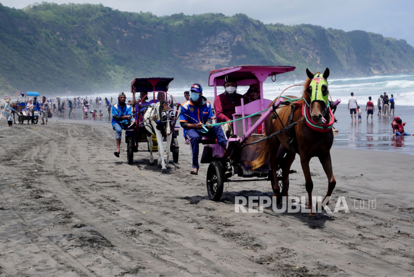 Andong wisata membawa wisatawan berkeliling di Pantai Parangtritis, Bantul, Yogyakarta. 