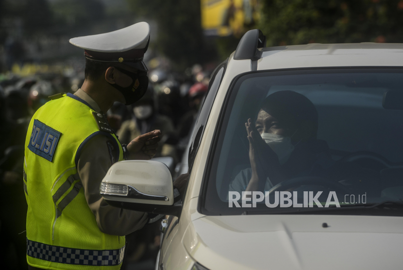 Polisi memberikan sosialisasi kepada pengendara mobil saat pemberlakuan ganjil genap di kawasan Fatmawati, Jakarta, Senin (25/10). Direktorat Lalu Lintas (Ditlantas) Polda Metro Jaya membebaskan aturan ganjil genap untuk dokter dan tenaga kesehatan atau nakes.