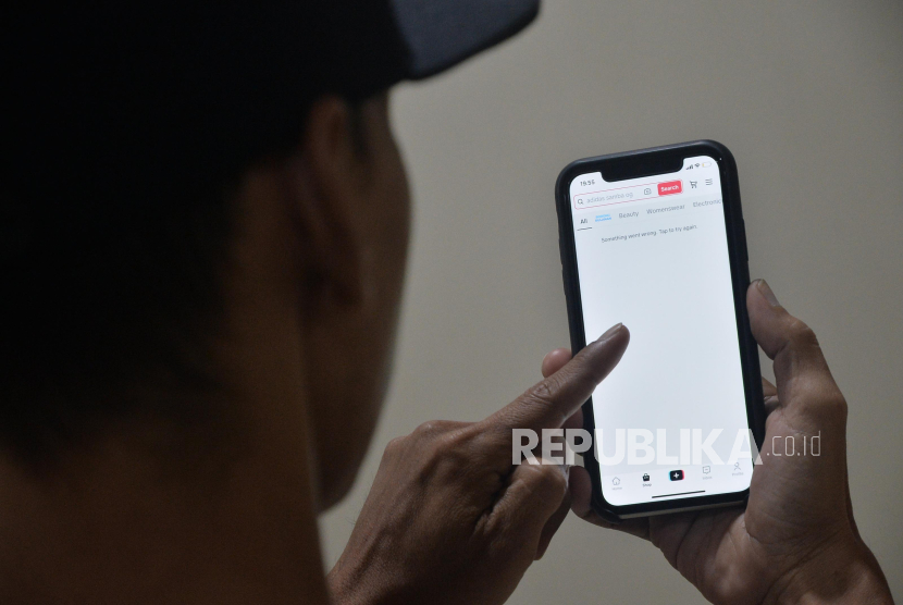 Pengguna TikTok menunjukkan laman TikTok Shop yang sudah tidak dapat diakses melalui telepon genggamnya di Jakarta, Rabu (4/10/2023). 