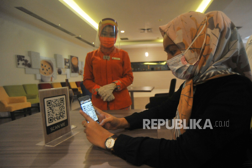 Seorang tamu melakukan pemesanan makanan dengan scan barcode di Hotel Grand Inna, Padang, Sumatera Barat, Sabtu (13/6/2020). Hari pertama masa normal baru di Padang, hotel Grand Inna menerapkan protokol kesehatan COVID-19 di antaranya melakukan disinfektan kamar sebelum digunakan dan pelayanan digitalisasi menu makanan menggunakan QR Code