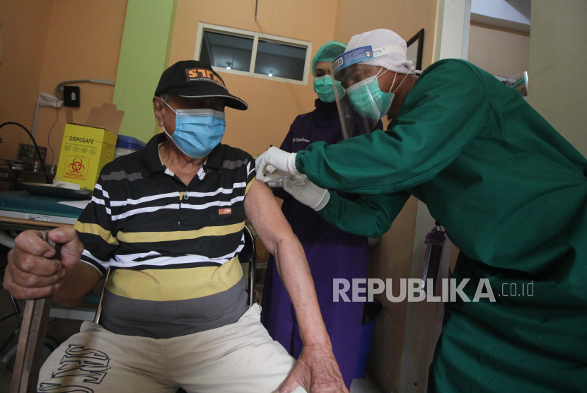 Petugas kesehatan menyuntikan vaksin COVID-19 kepada seorang warga lanjut usia (lansia) di Puskesmas Pakis, Surabaya, Jawa Timur, Selasa (23/2/2021). Pada vaksinasi COVID-19 tahap kedua ini, warga lansia menerima suntikan vaksin sebagai bagian dari upaya penanggulangan pandemi. 