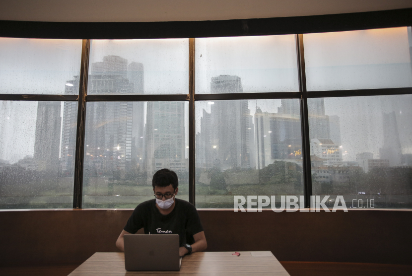 Pengunjung mengoperasikan laptop di salah satu pusat perbelanjaan di kawasan Kuningan, Jakarta, Kamis (18/2/2021). Bank Indonesia (BI) memutuskan untuk kembali menurunkan suku bunga acuan alias BI 7 daya reverse repo rate sebesar 25 basis poin (bps) menjadi 3,5 persen. 