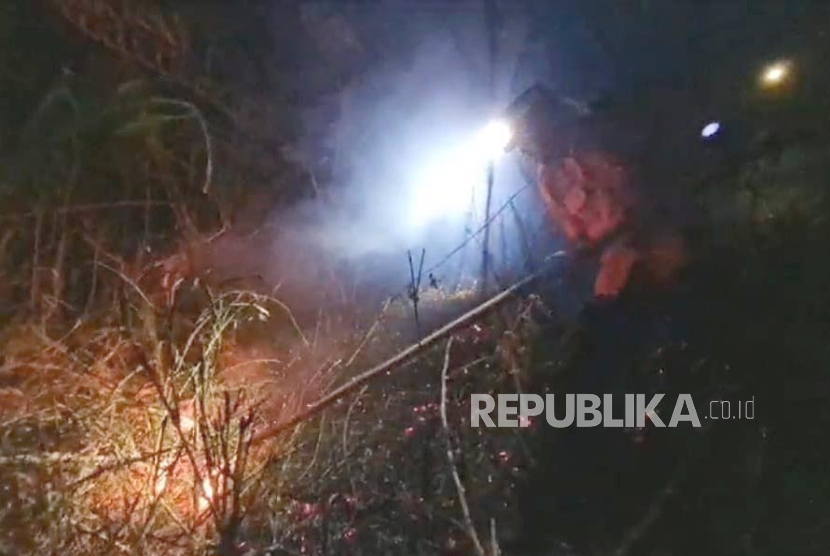 Petugas berupaya memadamkan kebakaran lahan di kawasan Blok Puncak Manik, Desa Cimulya, Kecamatan Cimahi, Kabupaten Kuningan, Jawa Barat, Selasa (26/9/2023) malam.