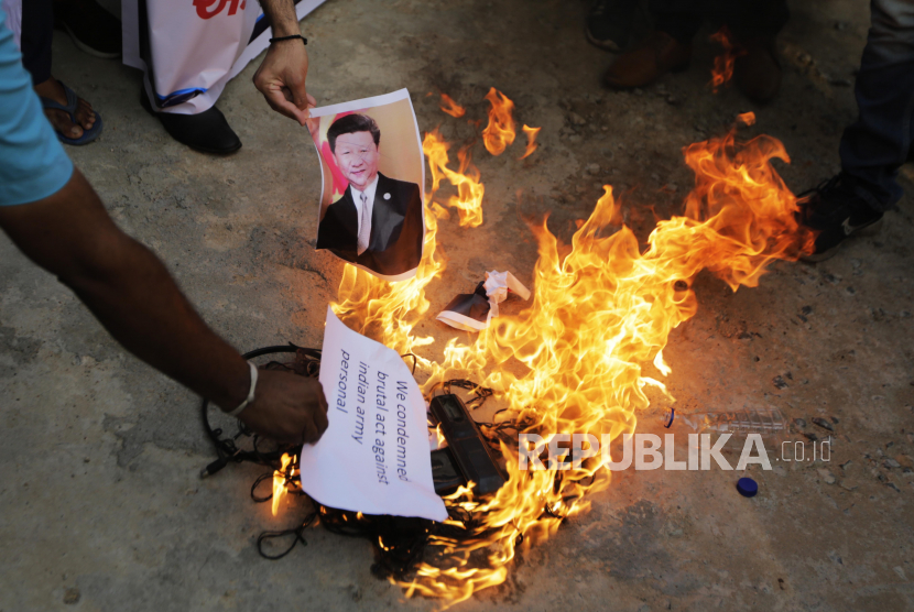 Seorang lelaki India membakar foto presiden China Xi Jinping saat protes terhadap China di Ahmedabad, India, Selasa, 16 Juni 2020