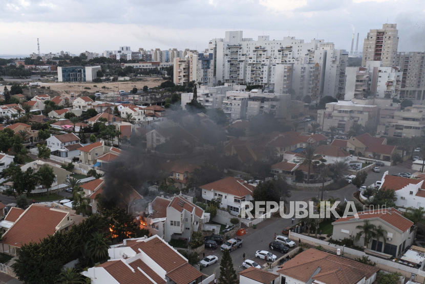 Asap mengepul setelah roket yang ditembakkan dari Jalur Gaza menghantam sebuah rumah di Ashkelon, Israel selatan, Sabtu, 7 Oktober 2023. Roket tersebut ditembakkan saat Hamas mengumumkan operasi baru melawan Israel.