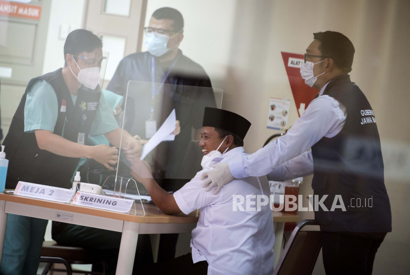 Gubernur Jawa Barat Ridwan Kamil (kanan) mendampingi Wakil Gubernur Jawa Barat Uu Ruzhanul Ulum (kedua kanan) sebelum vaksinasi COVID-19 Sinovac di Rumah Sakit Hasan Sadikin (RSHS), Bandung, Jawa Barat, Kamis (14/1/2021). Uu Ruzhanul Ulum menjadi orang pertama di Provinsi Jawa Barat yang menerima vaksinasi COVID-19 Sinovac menandakan dimulainya program vaksinasi massal di sejumlah daerah di Jawa Barat. 