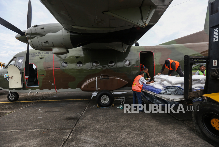 Sejumlah petugas memasukan garam kedalam pesawat Cassa A-2104 untuk persemaian garam dengan Teknologi Modifikasi Cuaca (TMC) di Skadron Udara 2, Halim Perdanakusuma, Jakarta. 