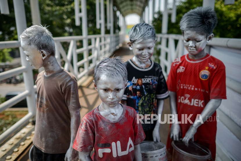 Anak-anak menjadi manusia silver di jembatan penyeberangan orang (JPO) Pasar Gembrong, Jakarta Timur.