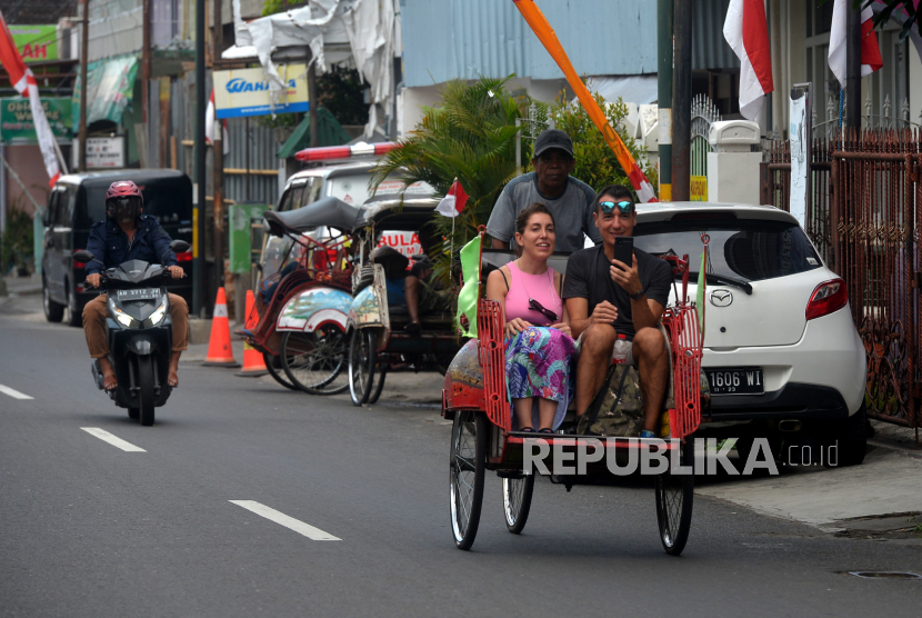 Wisatawan mancanegara berkeliling menggunakan becak kayuh di Yogyakarta, Jumat (12/8/2022). Seiring turunnya kasus Covid-19 di Yogyakarta kunjungan wisman mulai terlihat . Jumlah kunjungan wisman ke Yogyakarta pada periode Januari-Mei 2022 mencapai 295 kunjungan.